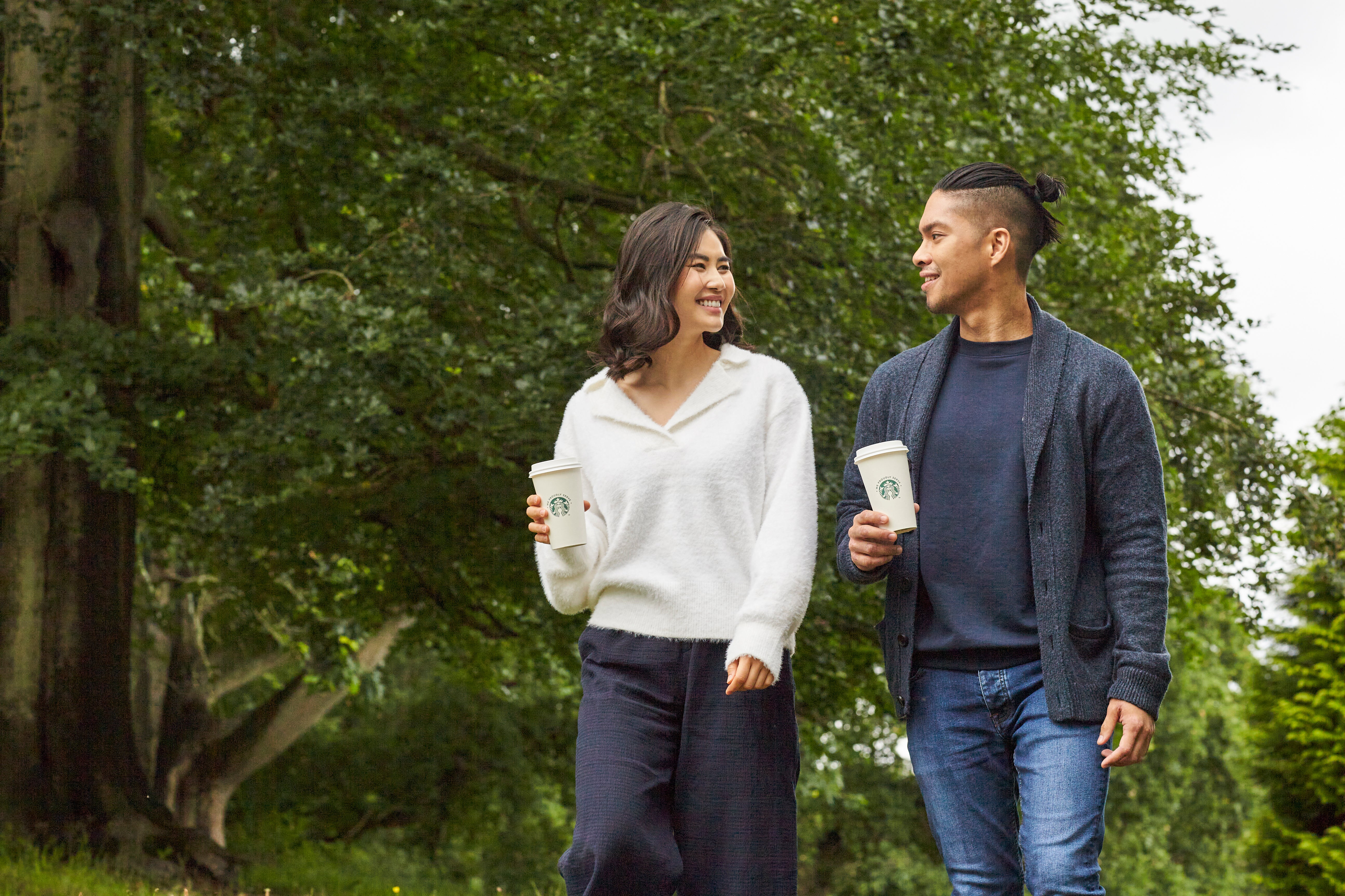 two people walking with a starbucks drink