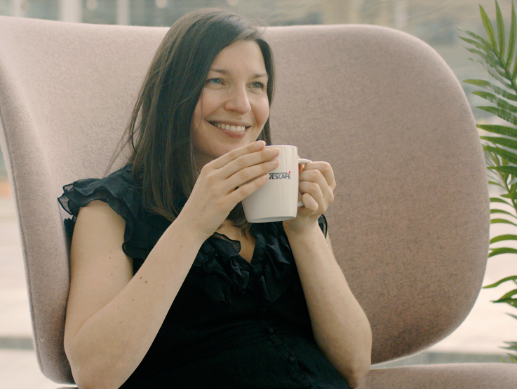 Woman sat in chair with coffee