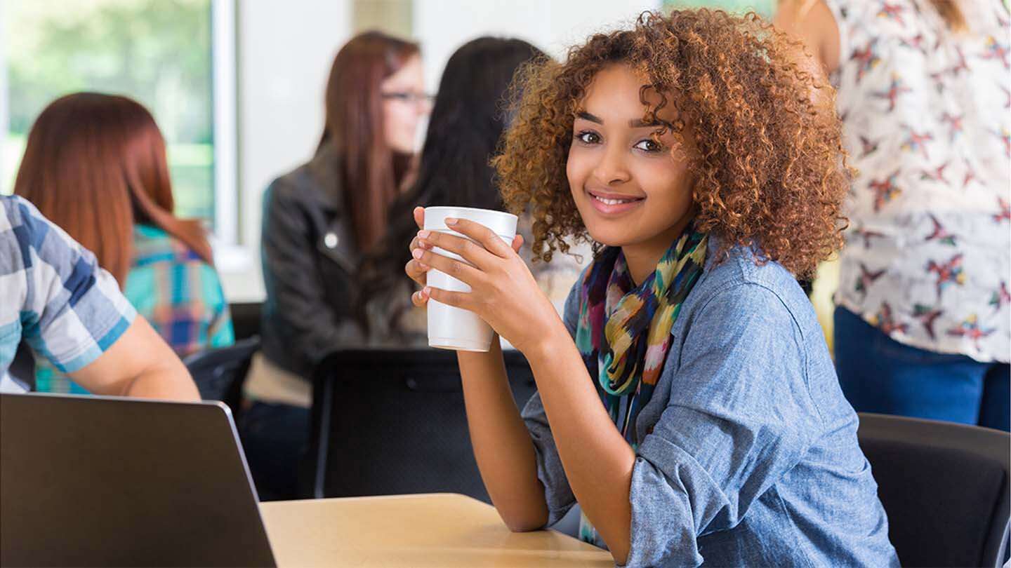 student drinking starbucks on campus