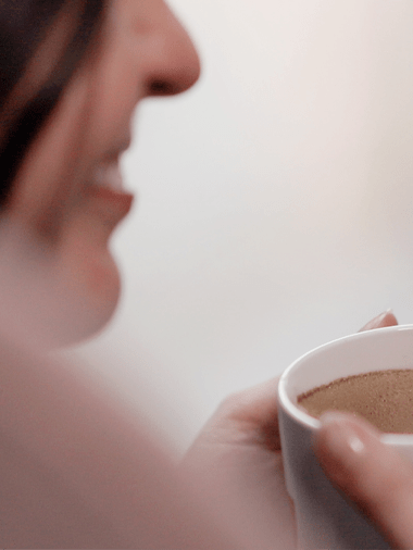 Woman smiling with a cup of coffee
