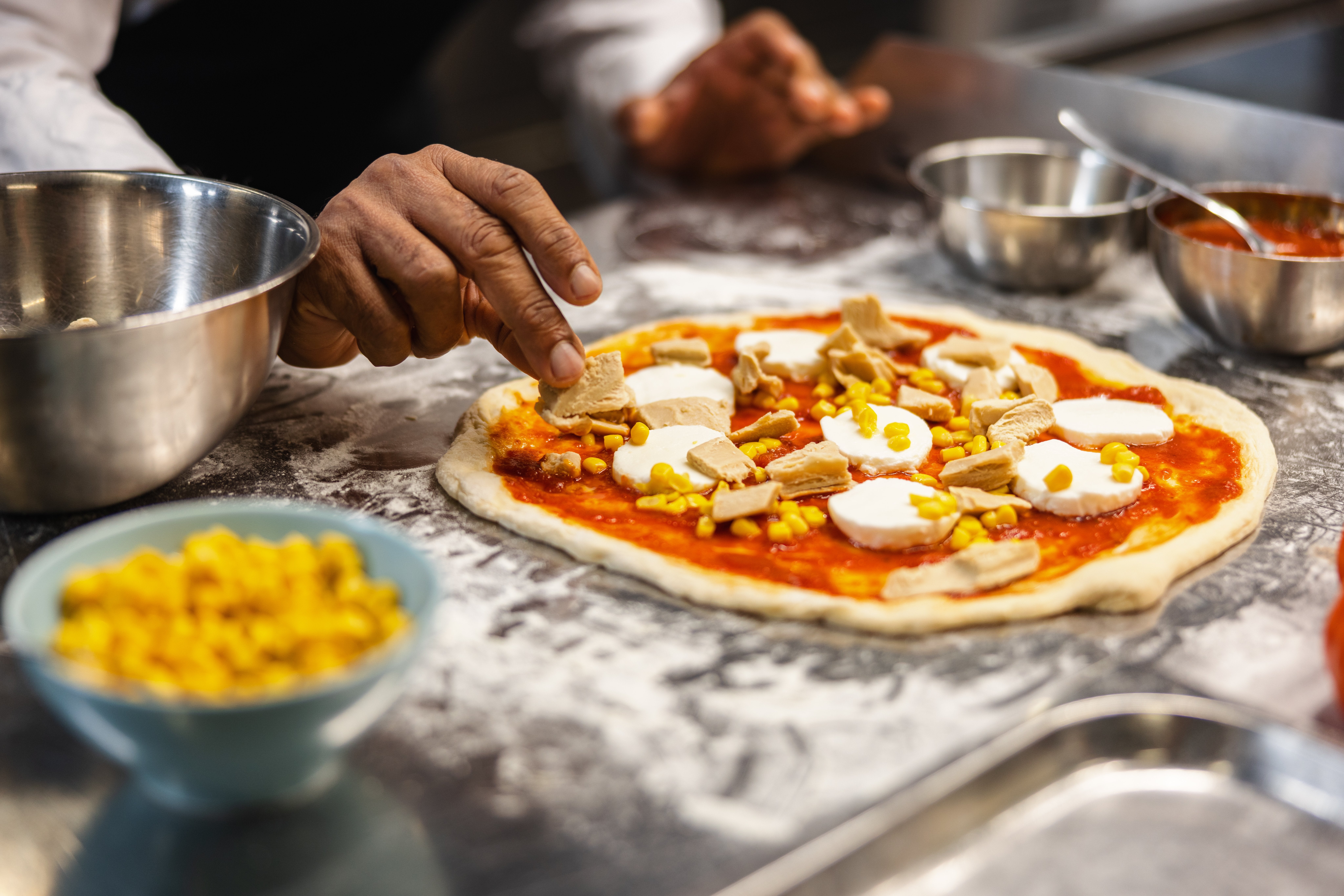chef making pizza using garden gourmet fillet pieces