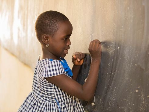 african girl writing on the board in a classroom