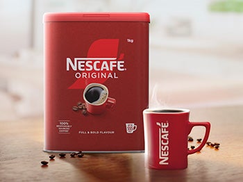 Nescafe lifestyle image of a Nescafe Original tin and iconic red mug